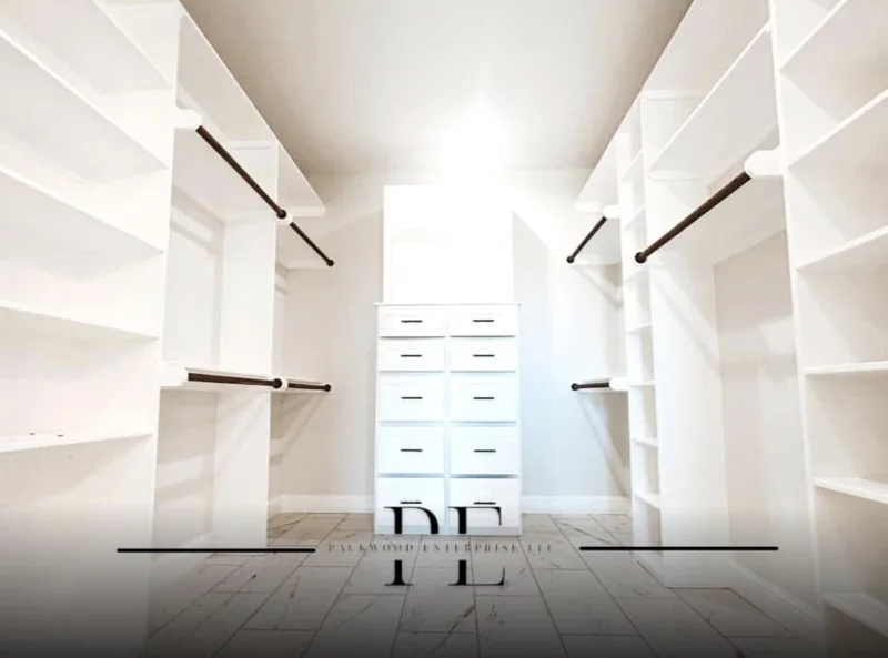 Bright walk-in closet with white shelves and drawers